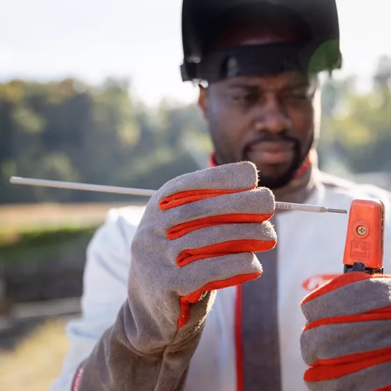 Person clamps a welding electrode