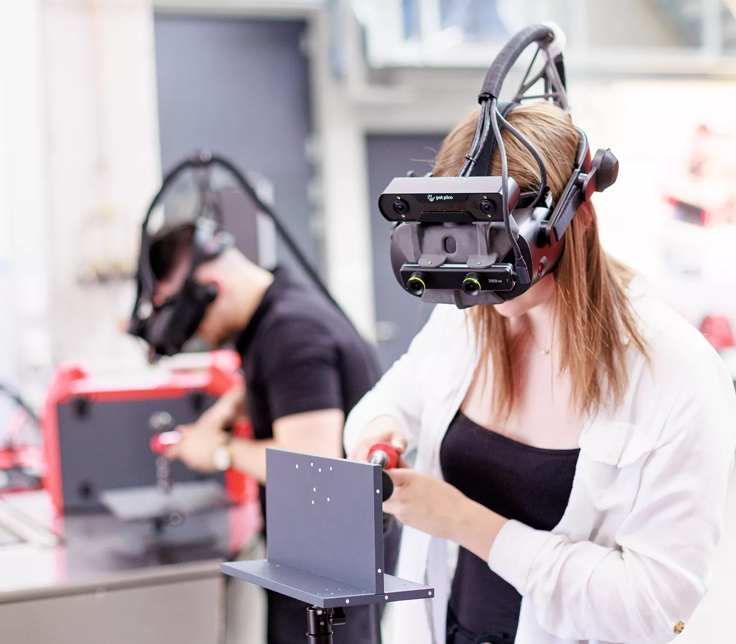 Two people are learning to weld with Welducation Simulator.