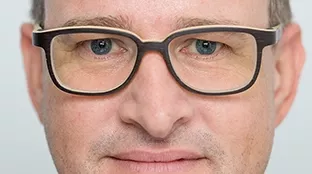 Fronius Mitarbeiter schaut mit fokussiertem Blick in die Kamera.