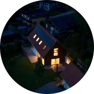 Haus in Dunkelheit mit eingeschalteten Lichtern